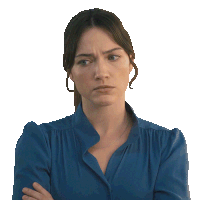 a woman in a blue shirt has her arms crossed and a serious look on her face