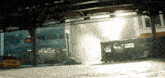 a yellow taxi is driving underneath a train with a sign that says subway