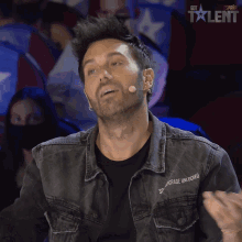 a man wearing a denim jacket that says sixth grade unlocked