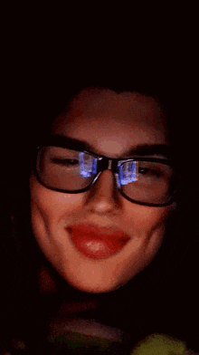 a close up of a woman wearing glasses and making a face .