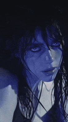 a close up of a woman 's face with a dark blue background