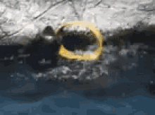 a yellow ring is floating in the water near a hole in the ground .