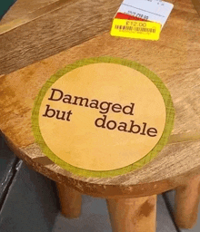 a damaged but doable sticker on a wooden table