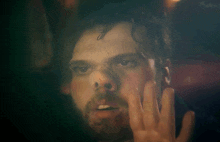 a close up of a man 's face with a hand on his face