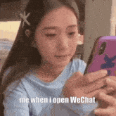 a woman is looking at her phone and says me when i open wechat .