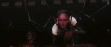 a woman with red hair and a mask is holding a sword in her hand .