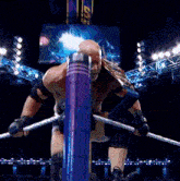 a man in a wrestling ring holding a rope with the word ufc on the screen behind him