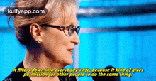a woman with glasses is talking into a microphone and says it filters down into everybody 's life .