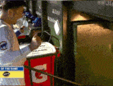 a man in a chicago cubs jersey is standing next to a gatorade cooler