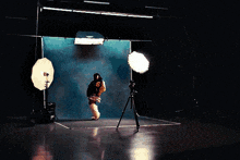 a pixelated image of a woman standing in a room with a tripod