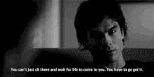 a black and white photo of a man sitting on a couch with a quote on the bottom .