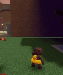 a gingerbread man wearing a yellow rubber duck float is standing on the grass
