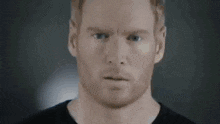 a close up of a man 's face with a black shirt on .