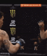 two men are fighting in a ring with a sign that says howler head