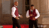 two waiters are dancing in front of a restaurant that says comedy central on the side