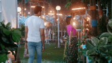 a man and a woman are standing in a garden at night