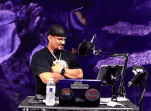 a man sitting in front of a laptop with a sticker on it that says gm