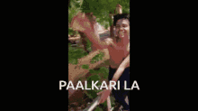 a shirtless boy standing on a sidewalk with the words paalkari la written below him