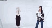 a group of women are standing next to each other in a room and laughing .