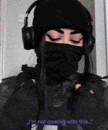 a woman wearing headphones and a black mask says " i 'm not dealing with this "