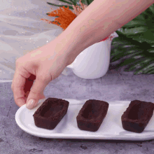 a person reaches for a chocolate cup on a plate