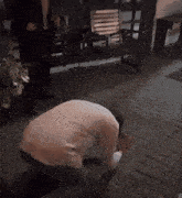 a man in a white shirt is kneeling down on a brick sidewalk