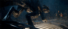 a group of people are standing in front of a giant monster in a dark room .