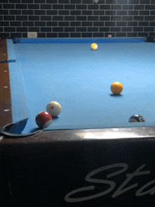pool balls on a blue table with the word sta on the side
