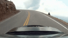 a car is driving down a road with a person standing on the side of it .