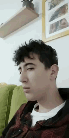 a young man is sitting on a couch in a living room .