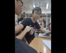 a boy with glasses holds a lollipop in his hand