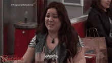 a woman wearing a green shirt that says hadow sits at a table