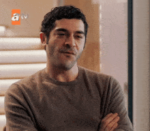 a man with his arms crossed is on a tv screen