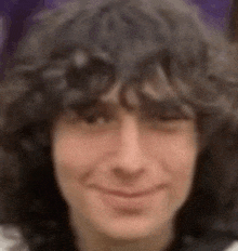 a close up of a person 's face with curly hair .