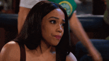a woman wearing a green shirt with a clock on it looks to the side