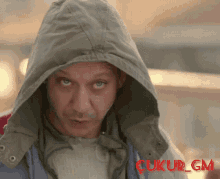 a man wearing a hooded jacket with the word ukur gm written on the bottom