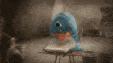 a blue stuffed animal is sitting on a table with a pizza on it .