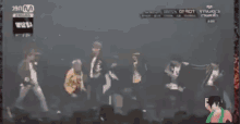 a blurred image of a crowd of people with the word m on the bottom left