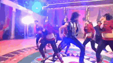 a group of people are dancing on a stage in a club
