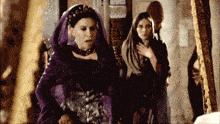 a woman in a purple dress with a crown on her head