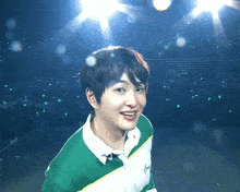 a young man wearing a green and white sweater with the letter a on the front