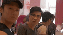 a man wearing glasses sits in front of a sign that says monkey poke