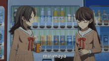 two girls are standing in front of a vending machine and the word mirimaya is on the bottom right