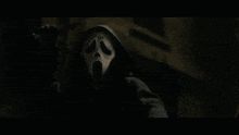 a close up of a person wearing a scream mask with their mouth open .