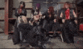 a group of men are standing around a woman in a chair with a mask on her face .