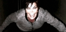 a woman is making a scary face in the dark .