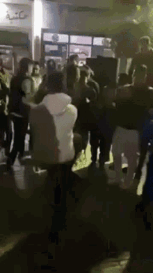 a group of people are gathered in a dark room with a sign that says kfc on it