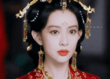 a close up of a woman wearing a red and gold dress
