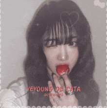 a girl is holding a strawberry in her mouth with the name yeyoung de cata on the bottom