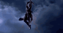 a silhouette of a person holding a sword in the sky